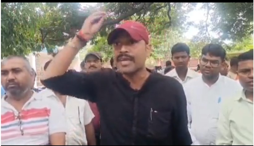 पलामू में बर्खास्त 251 अनु सेवकों का डीसी कार्यालय के सामने प्रदर्शन करते हुए समूह, जिसमें एक प्रदर्शनकारी हाथ उठाकर नारे लगाते हुए नजर आ रहा है।